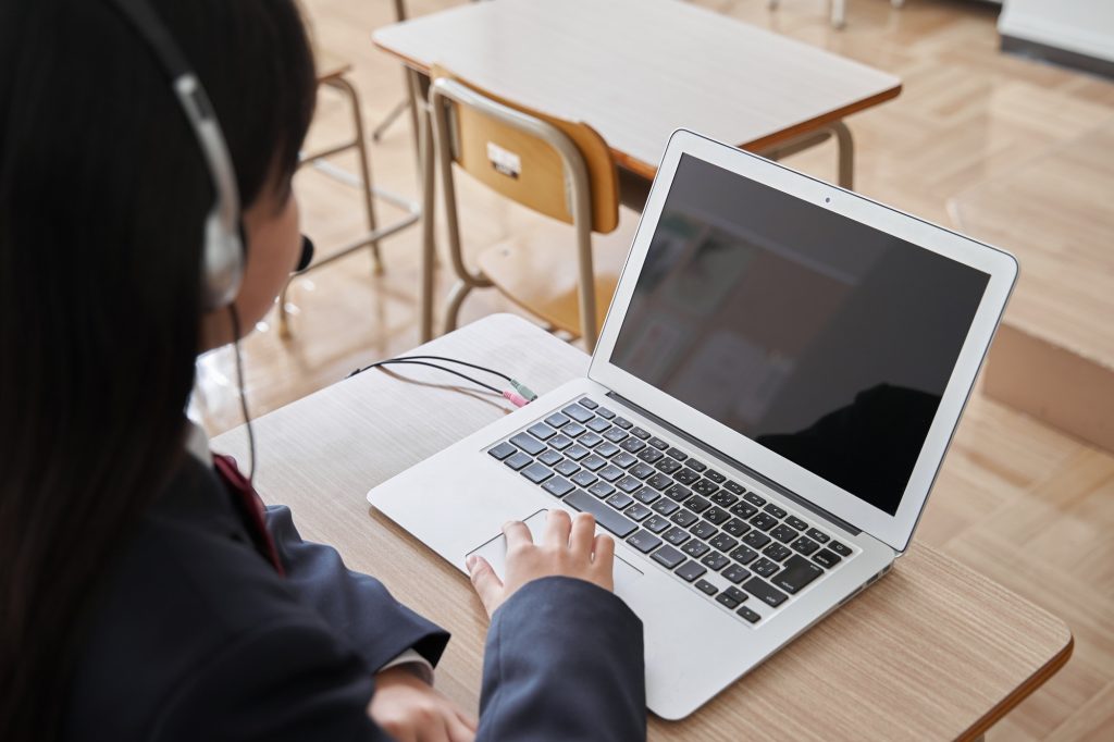 A Japanese junior high school girl takes a class on the computer in the classroom