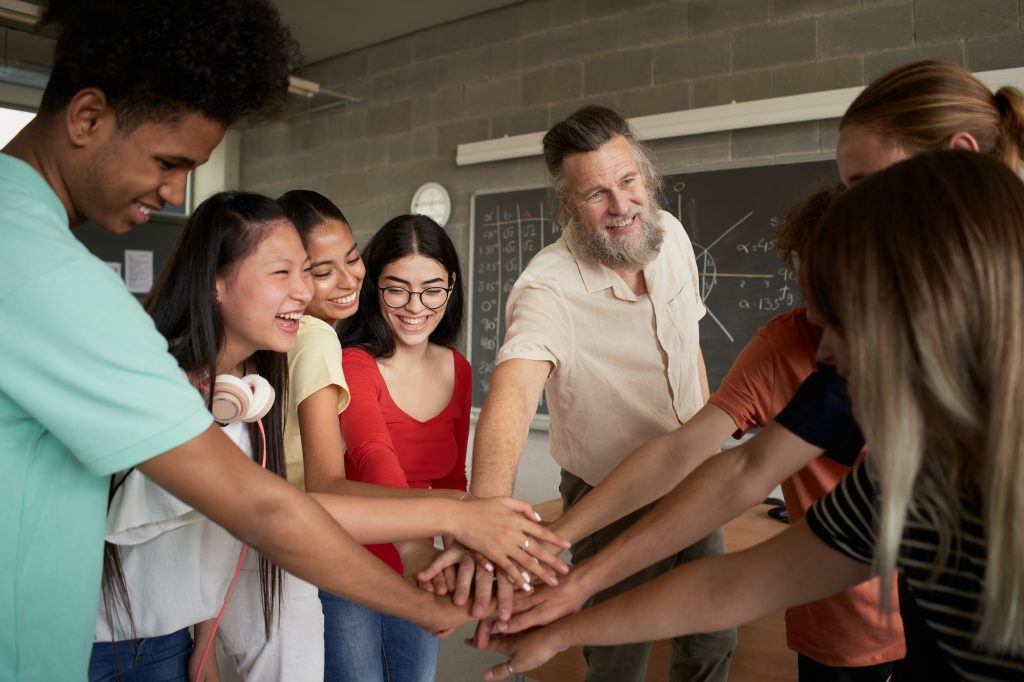 Group of students Teamwork with a teacher. Stacking Hand Concept.
