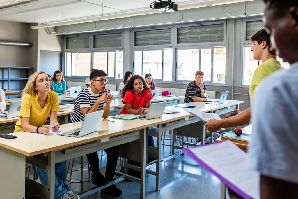 Young group of diverse high school students giving a presentation in classroom